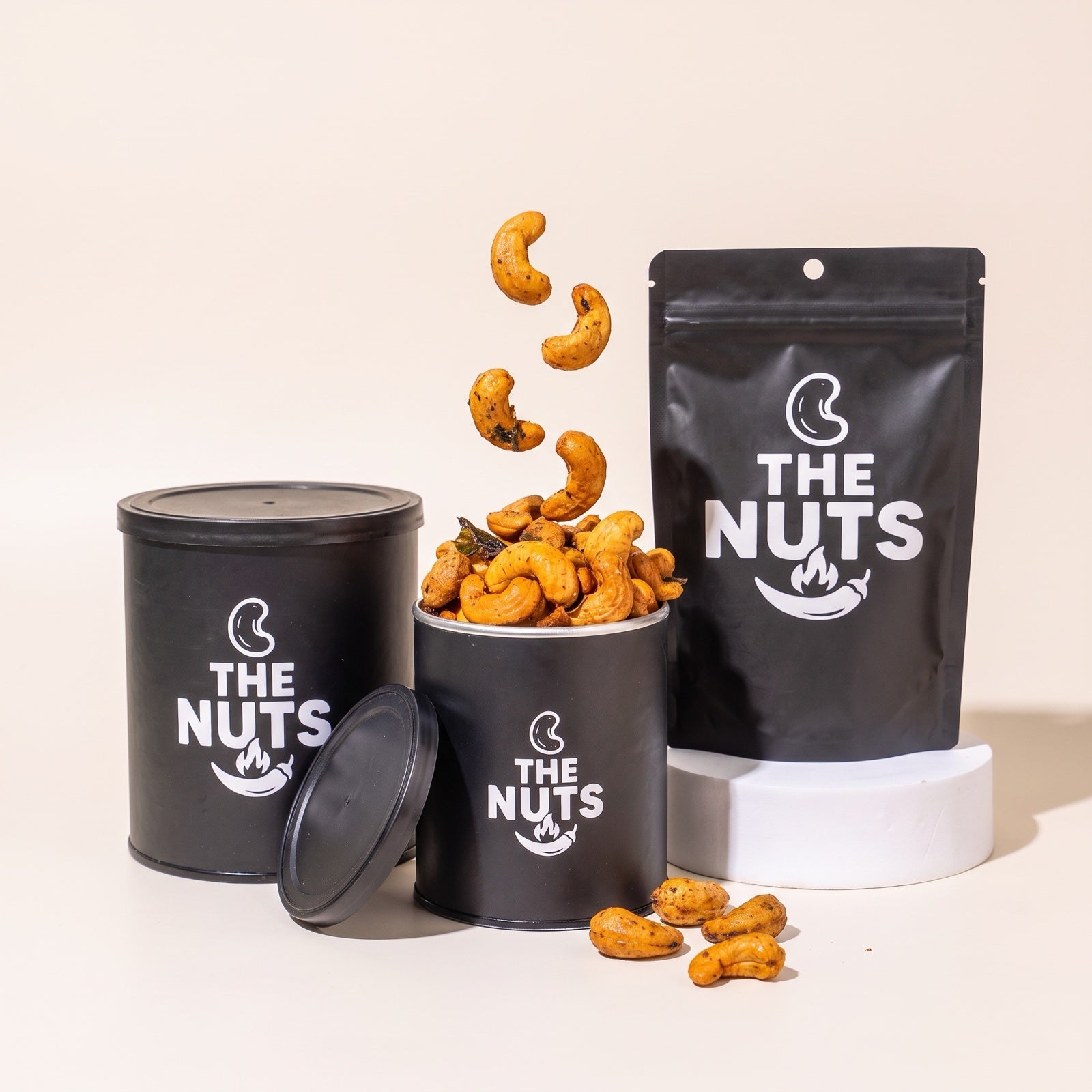 The Nuts range: 250g tin, open 120g tin with spicy cashews popping out, and 50g pouch
